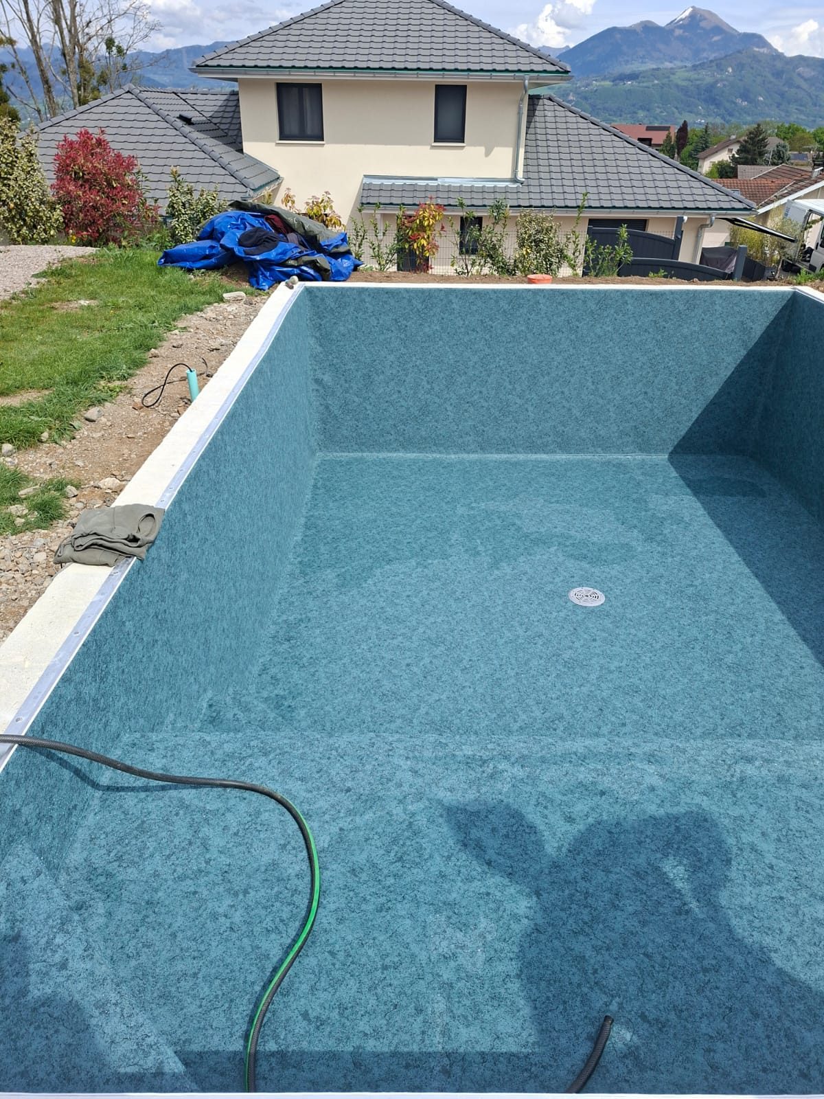 Chantier de pose de liner bleu, vue montagnes