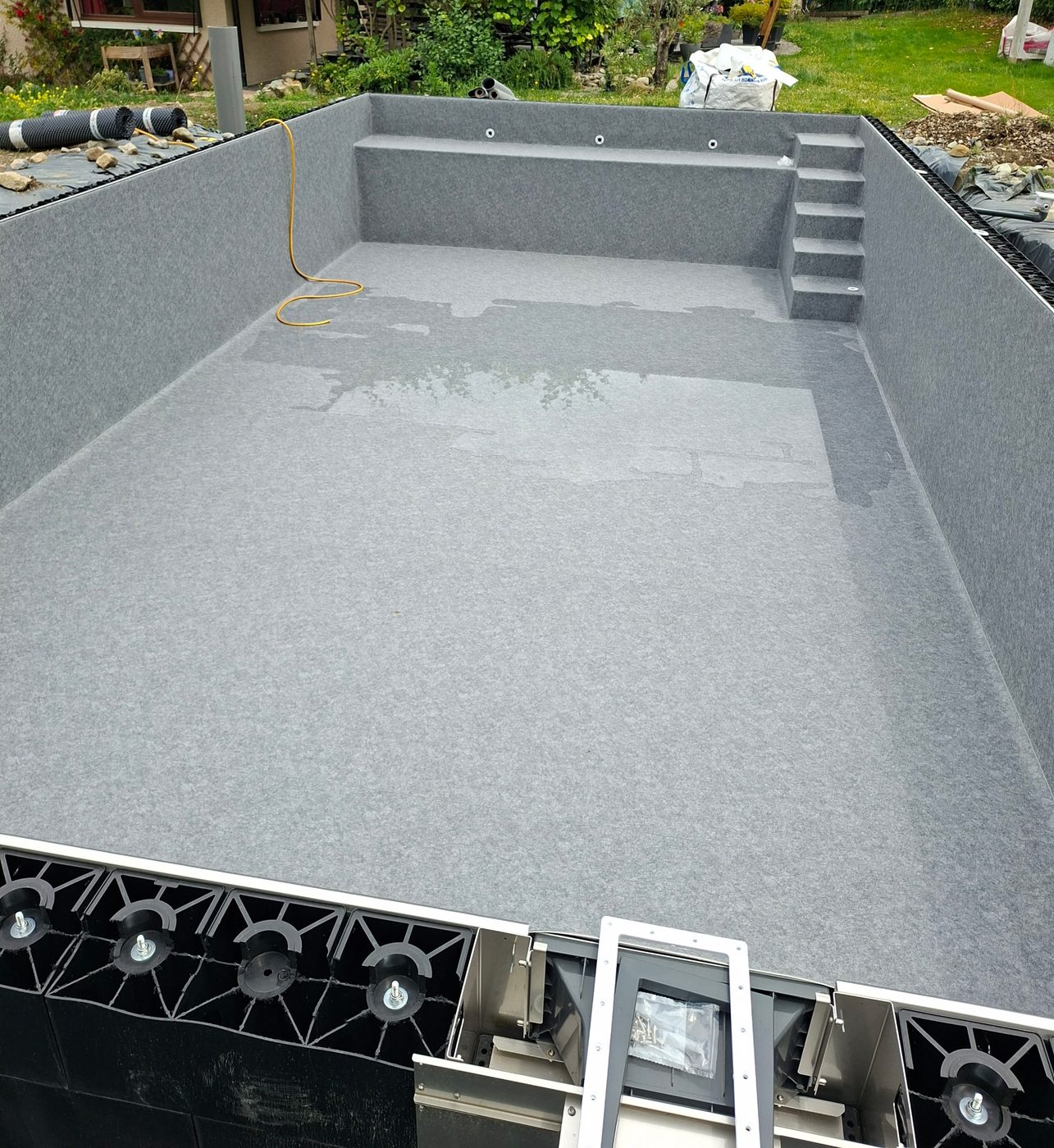Structure de bassin en panneaux avec liner gris posé
