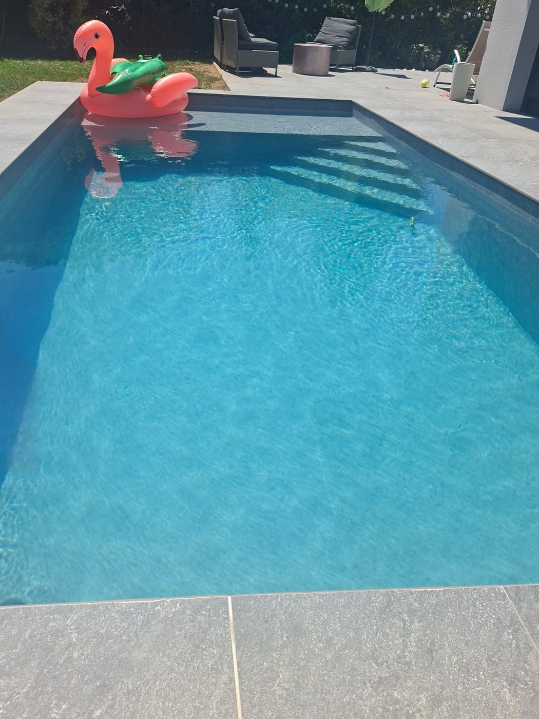 Piscine rénovée en liner gris avec terrasse en grès cérame